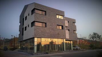 A modern multi-story building with a unique geometric design, large windows, and a glass facade.