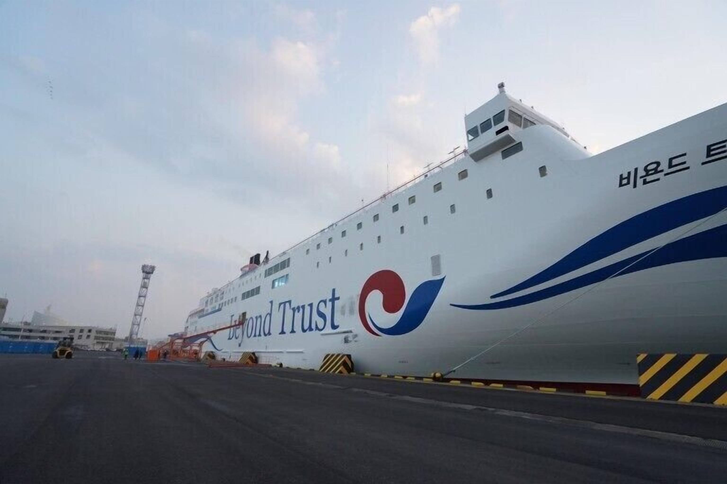 Un gran crucero con el nombre 'Beyond Trust' en su costado, amarrado en un puerto.