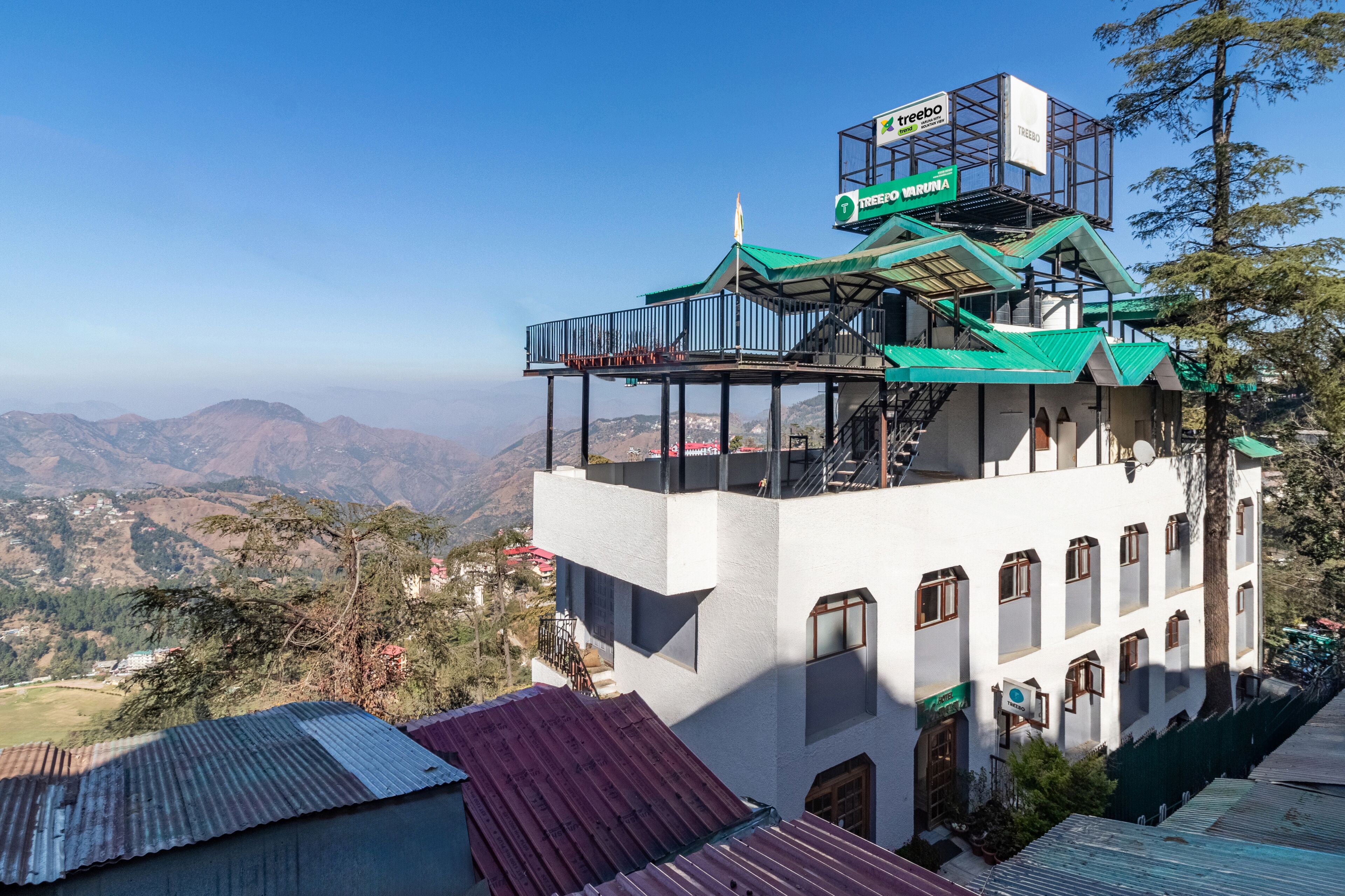 A multi-story building with a green roof and a balcony on the upper floor.