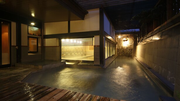 A modern building with a covered outdoor area and a stone wall.