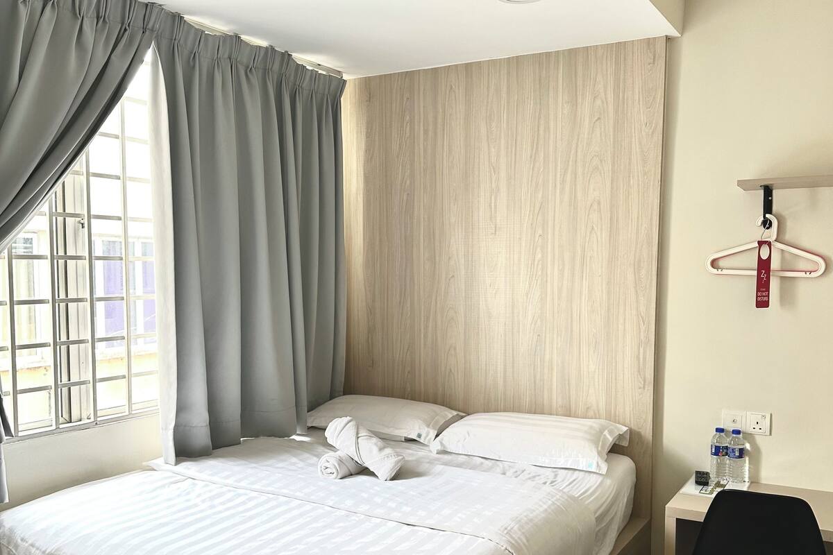 Quarto de hotel moderno com uma cama, uma escrivaninha e uma cadeira.