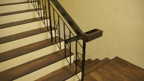 A wooden staircase with a black metal railing. - Hotel 57 Subang Jaya (Subang Jaya)