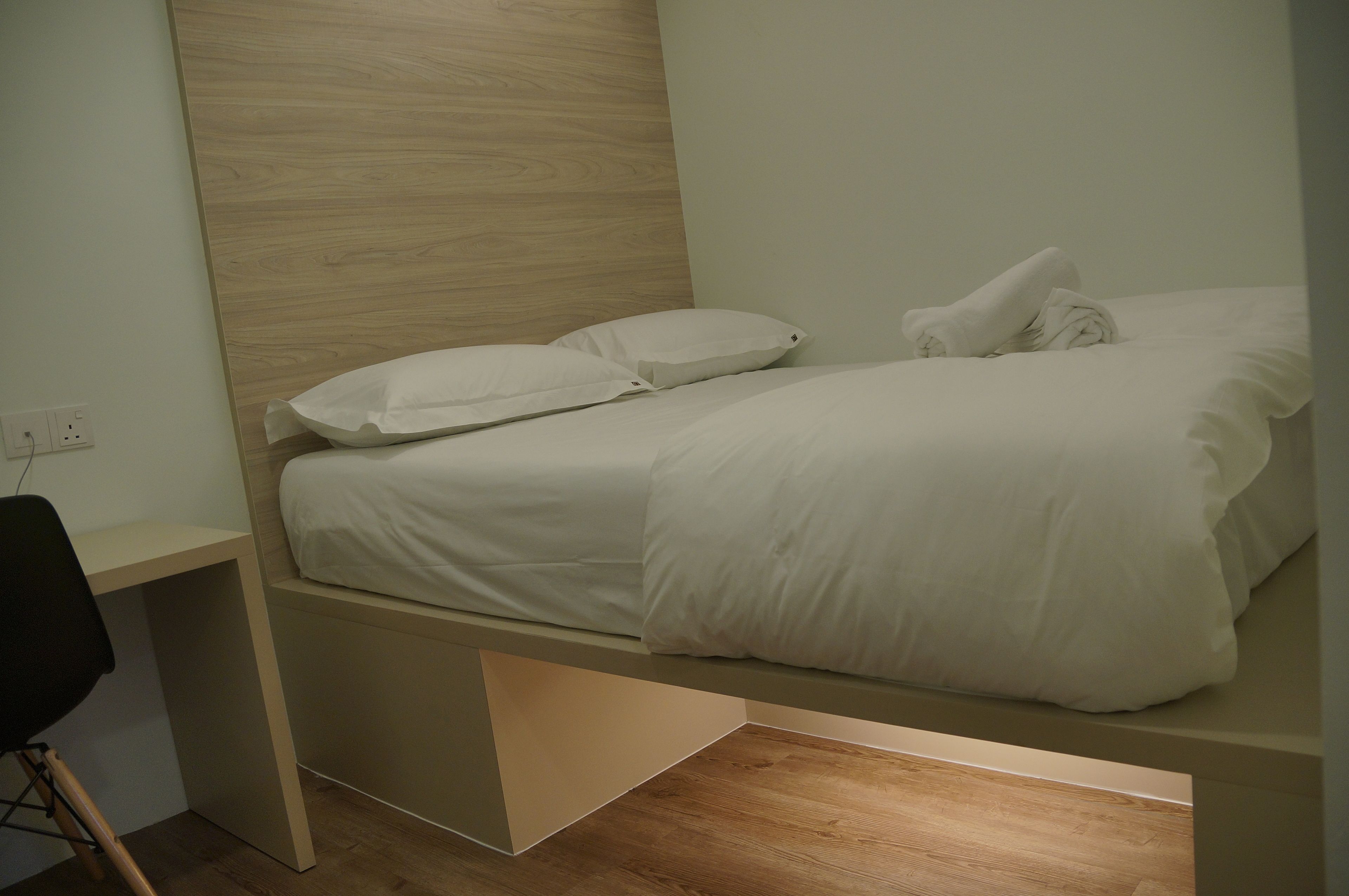 Un dormitorio pequeño con cama, escritorio y silla.