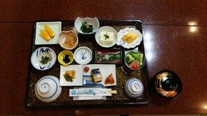 A tray with various food items and condiments, including pickled vegetables, tofu, and a small dish of salad. - Imakuni Ryokan (Takachiho)