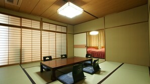 Um quarto japonês tradicional com tatames, uma mesa de madeira baixa e painéis shoji.
