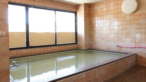 Uma grande piscina interior com paredes azulejadas e uma janela.