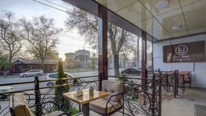 Een LULU Hotel Coffee & Lounge met buitenplaatsen, uitzicht op de straat en een bord aan de muur.