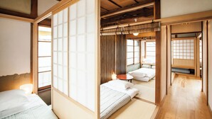 Una habitación tradicional japonesa con suelo de tatami, paneles shoji y techo de madera bajo.