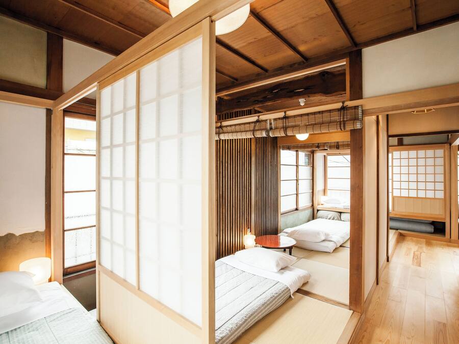 Een traditionele Japanse kamer met tatami vloerbedekking, shoji schermen en een laag houten plafond.