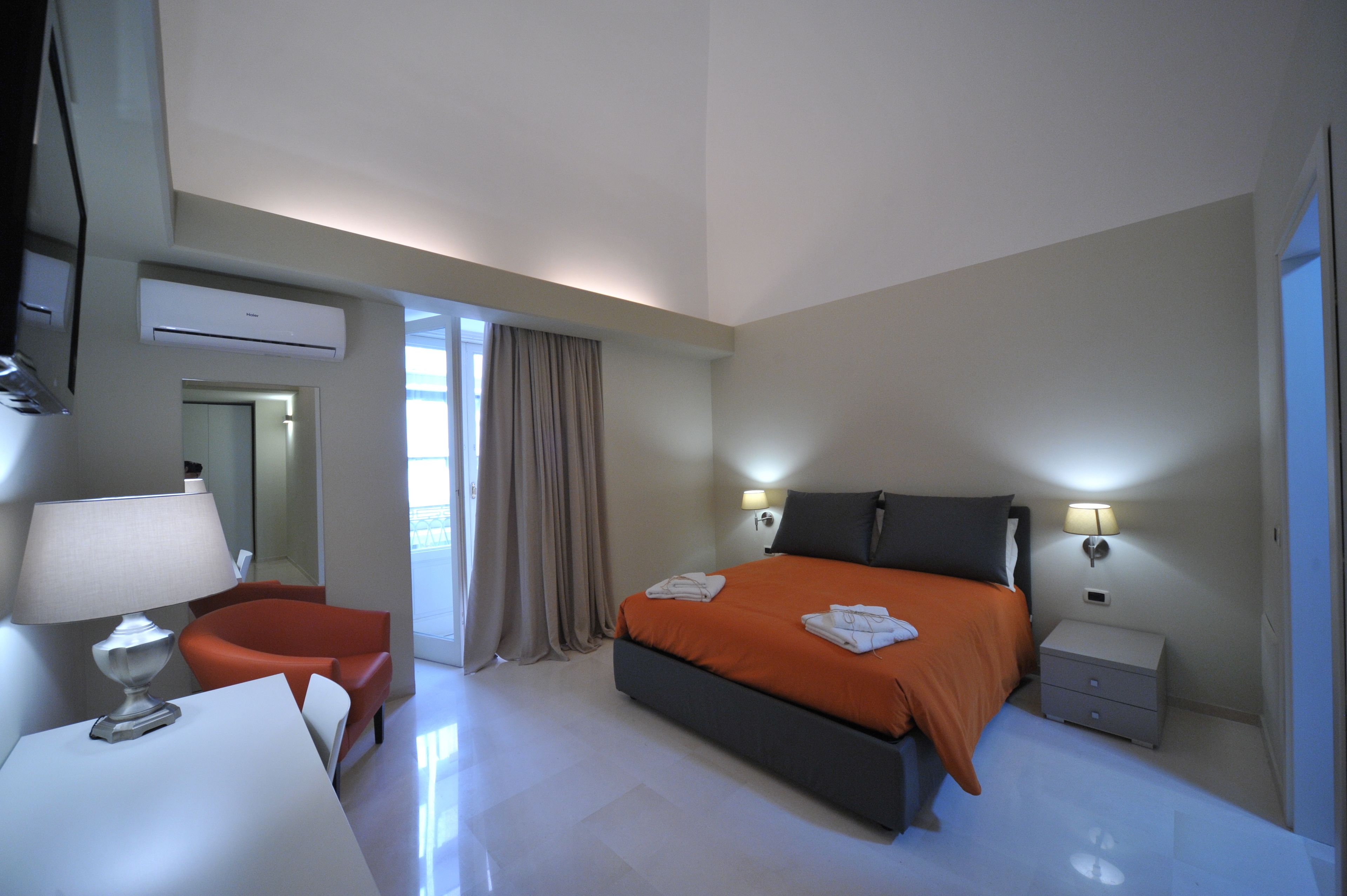 Een moderne hotelkamer met een groot bed, een bureau en een stoel.