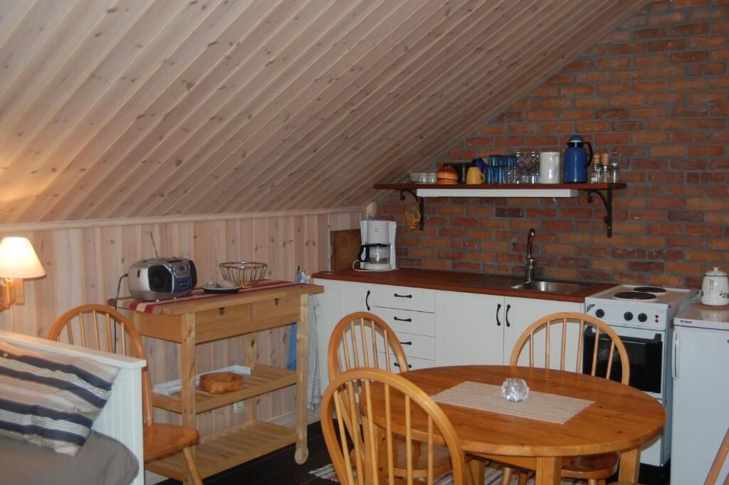 Ett mysigt kök med träskåp, en tegelvägg och ett matbord i trä.