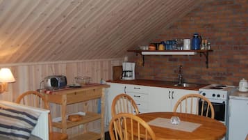 Ett mysigt kök med träskåp, en tegelvägg och ett matbord i trä.