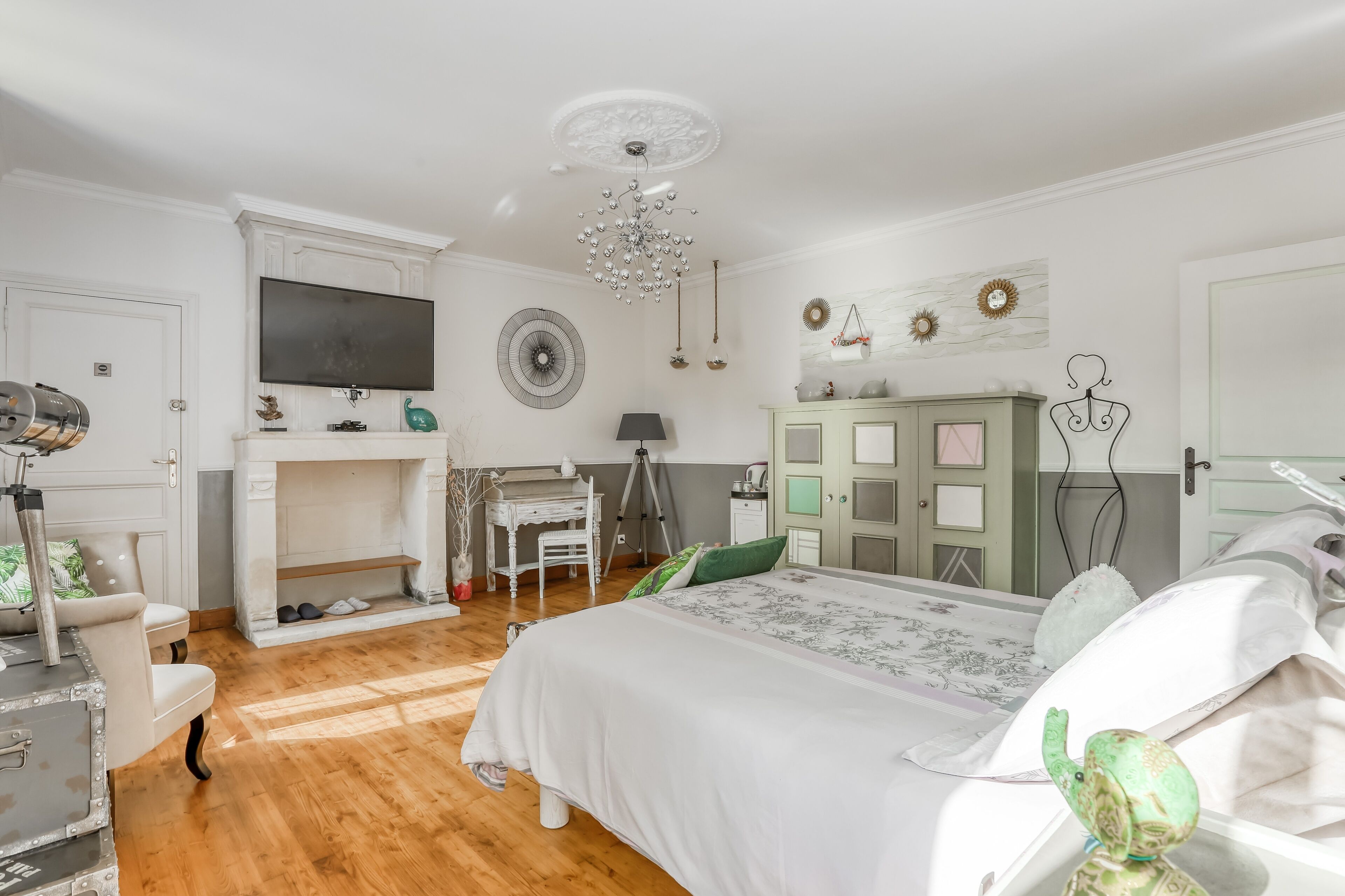 Un dormitorio con cama, escritorio, silla, armario y televisor.
