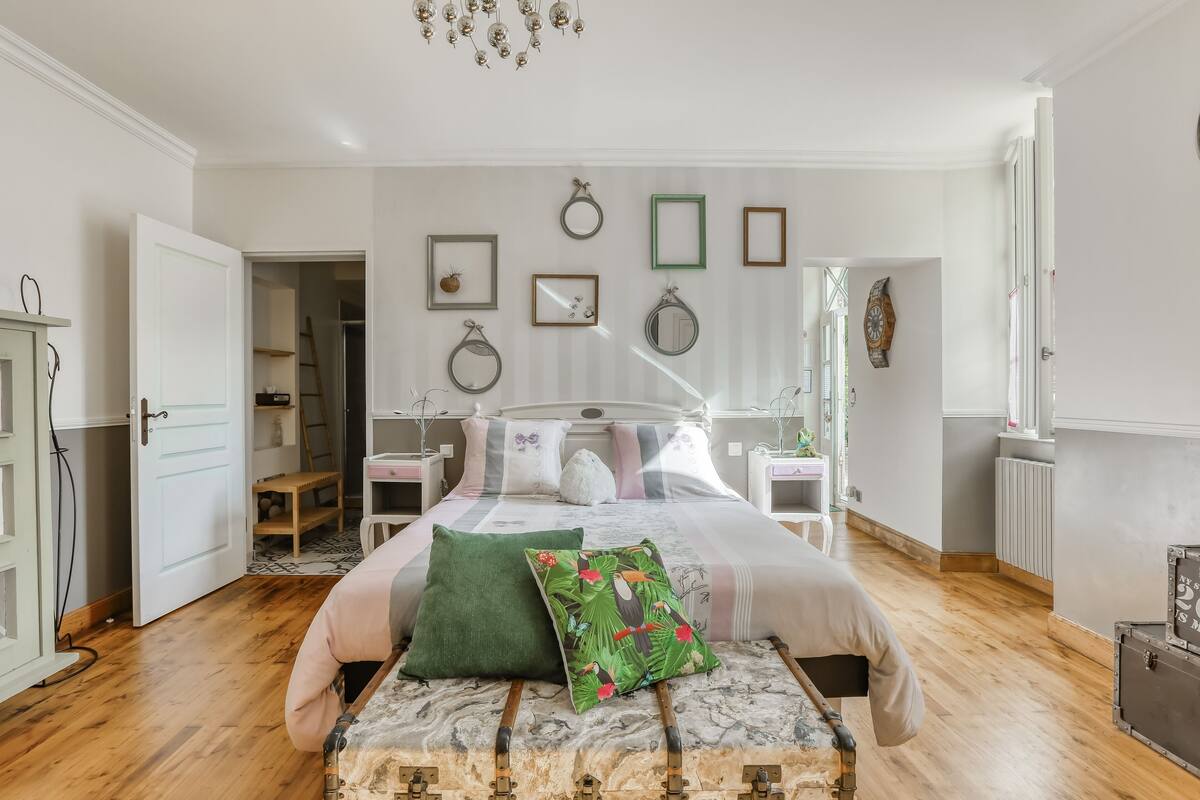 A bedroom with a bed, bedside tables, a wardrobe, and a chest of drawers.