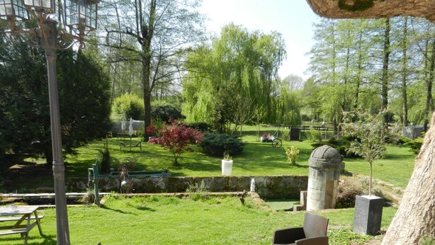 A garden with a fountain, seating area, and a stone structure. - Jolysable (Pons)