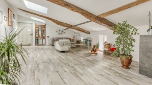 A spacious loft with exposed wooden beams, a high ceiling, and a rustic wooden floor. - Jolysable (Pons)