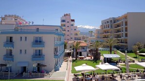 Un hôtel à étages, doté d’une terrasse et offrant une vue sur des montagnes enneigées en arrière-plan.