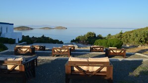 Terrasse extérieure avec vue sur la mer et les collines.