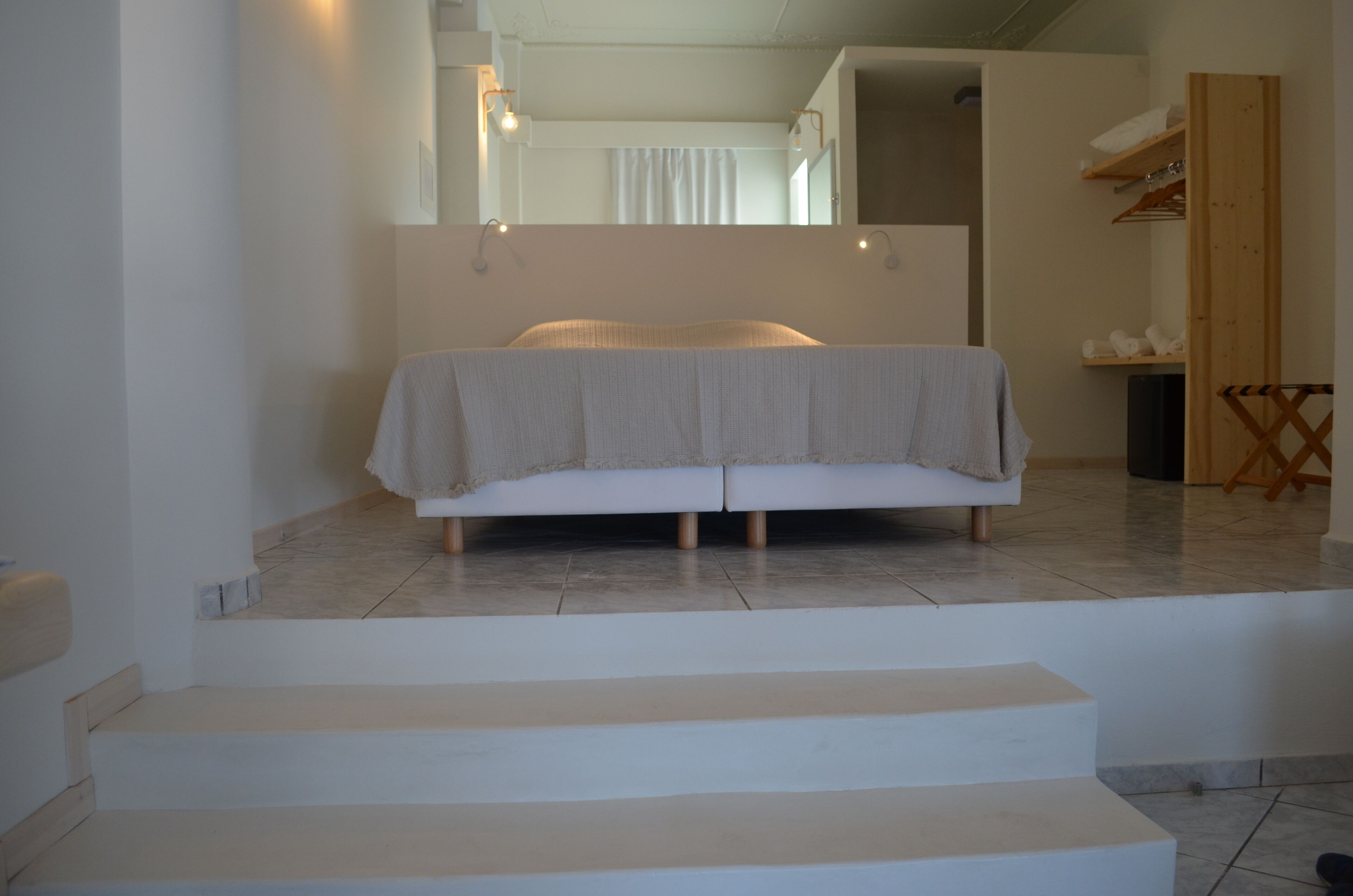 A bedroom with a bed, a wooden chair, and a small table.