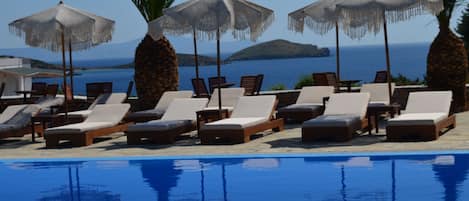 Una piscina al aire libre de temporada, sombrillas