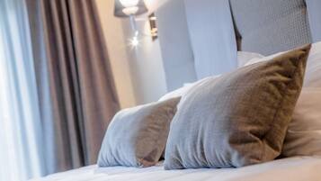 A neatly made bed with two pillows and a headboard.