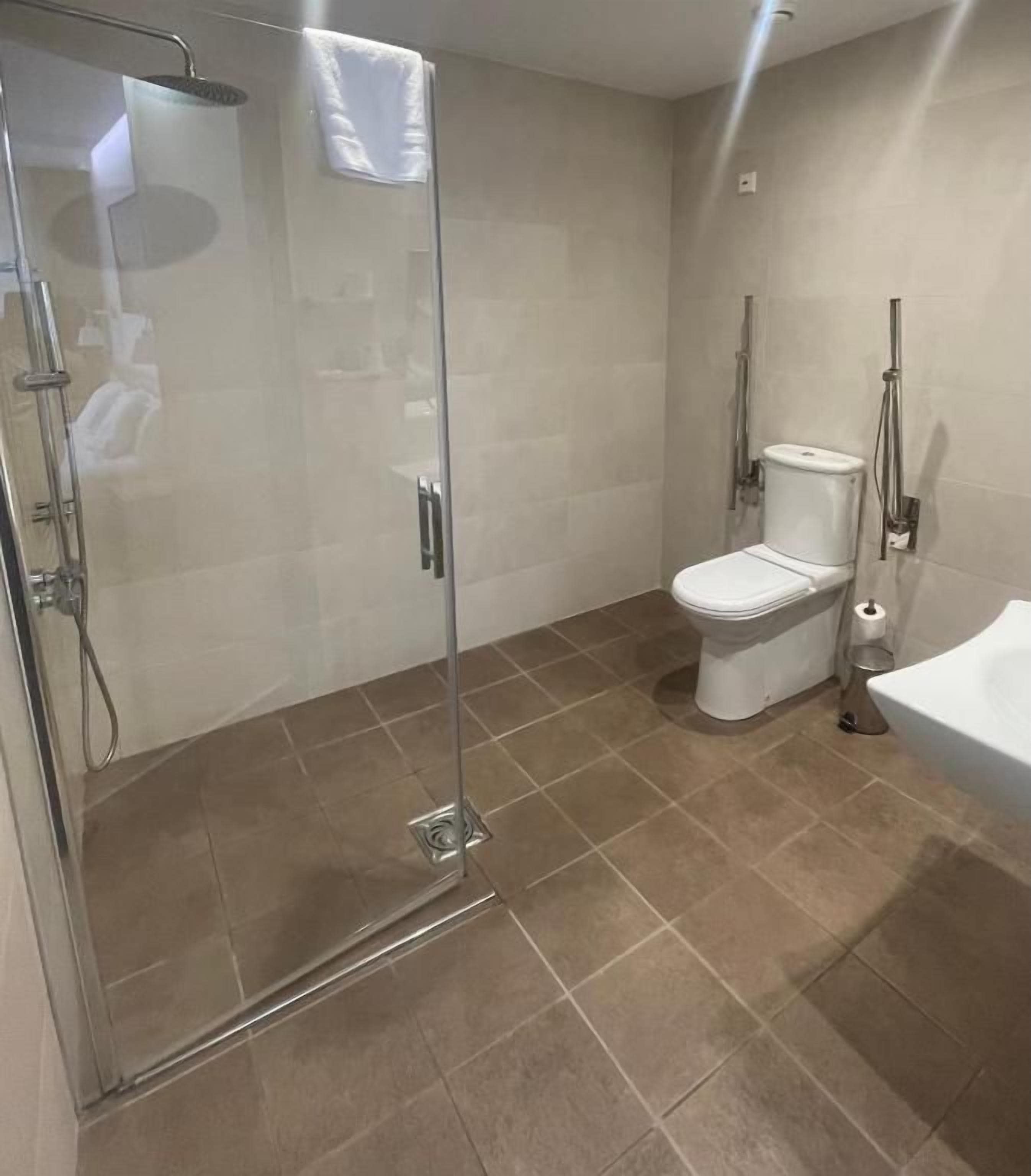 Un baño moderno con ducha acristalada, inodoro y bañera.
