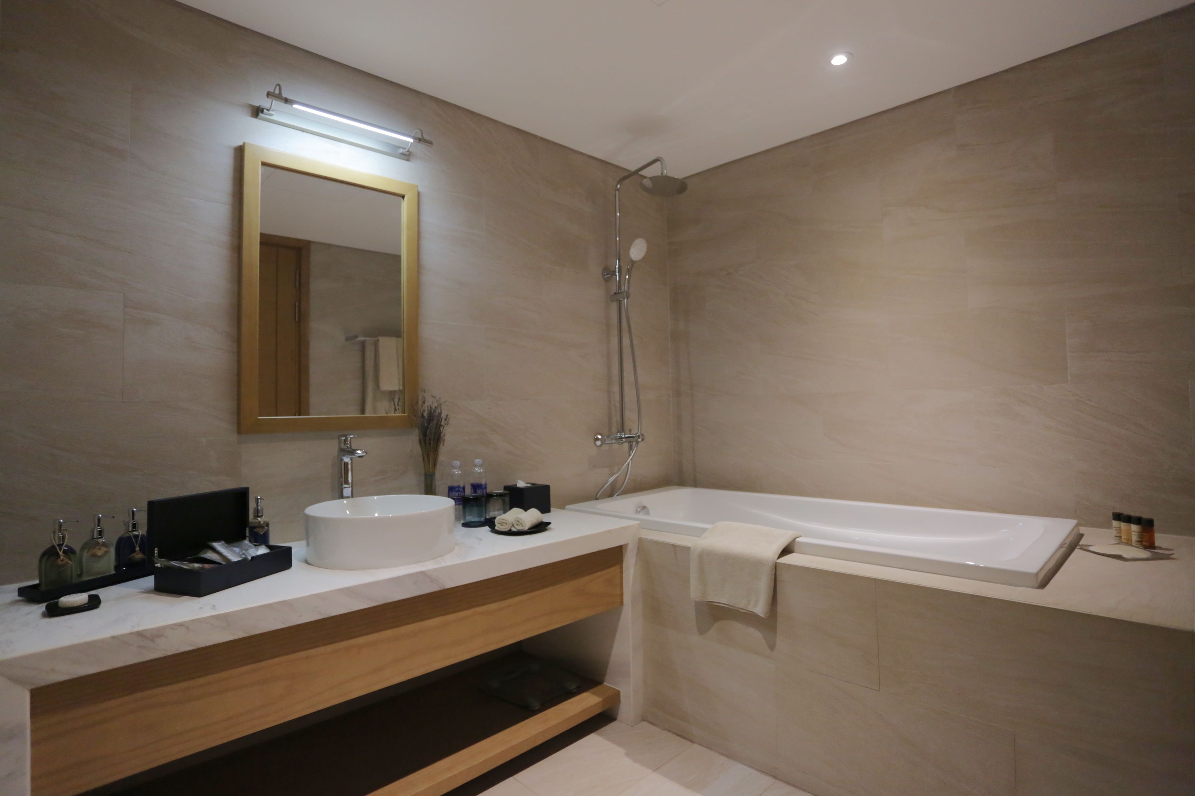 A modern bathroom with a large bathtub, a sink with a mirror, and a shower.