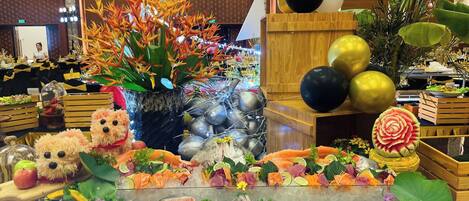 A seafood display with ice, surrounded by decorative plants and a teddy bear.