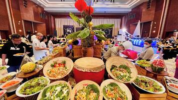 A buffet setup with various dishes and a decorative centerpiece.