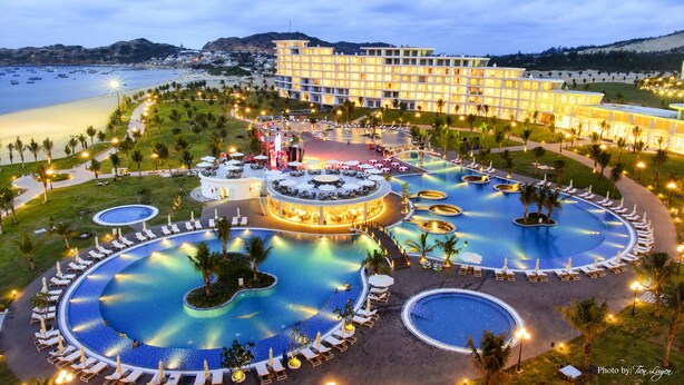 A resort with multiple swimming pools, a central bar, and a large hotel building.