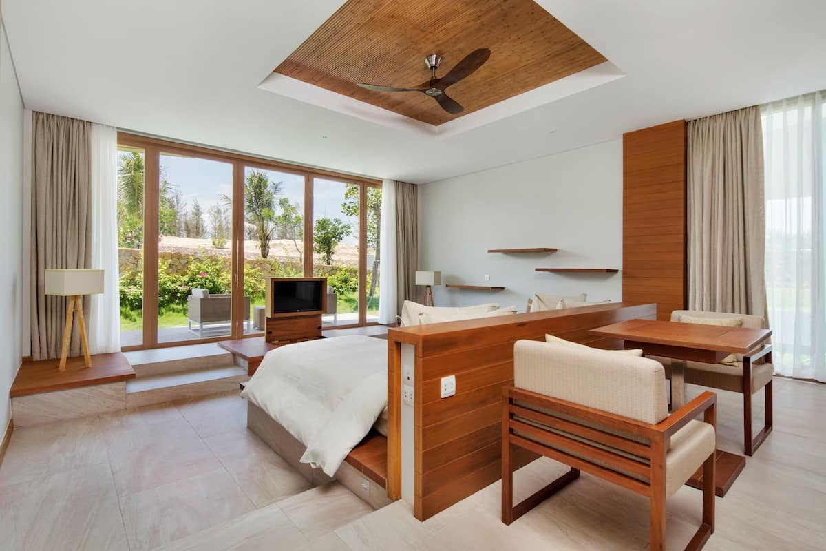 Une chambre d’hôtel moderne équipée d’un lit, d’un bureau, d’une chaise et d’un téléviseur.