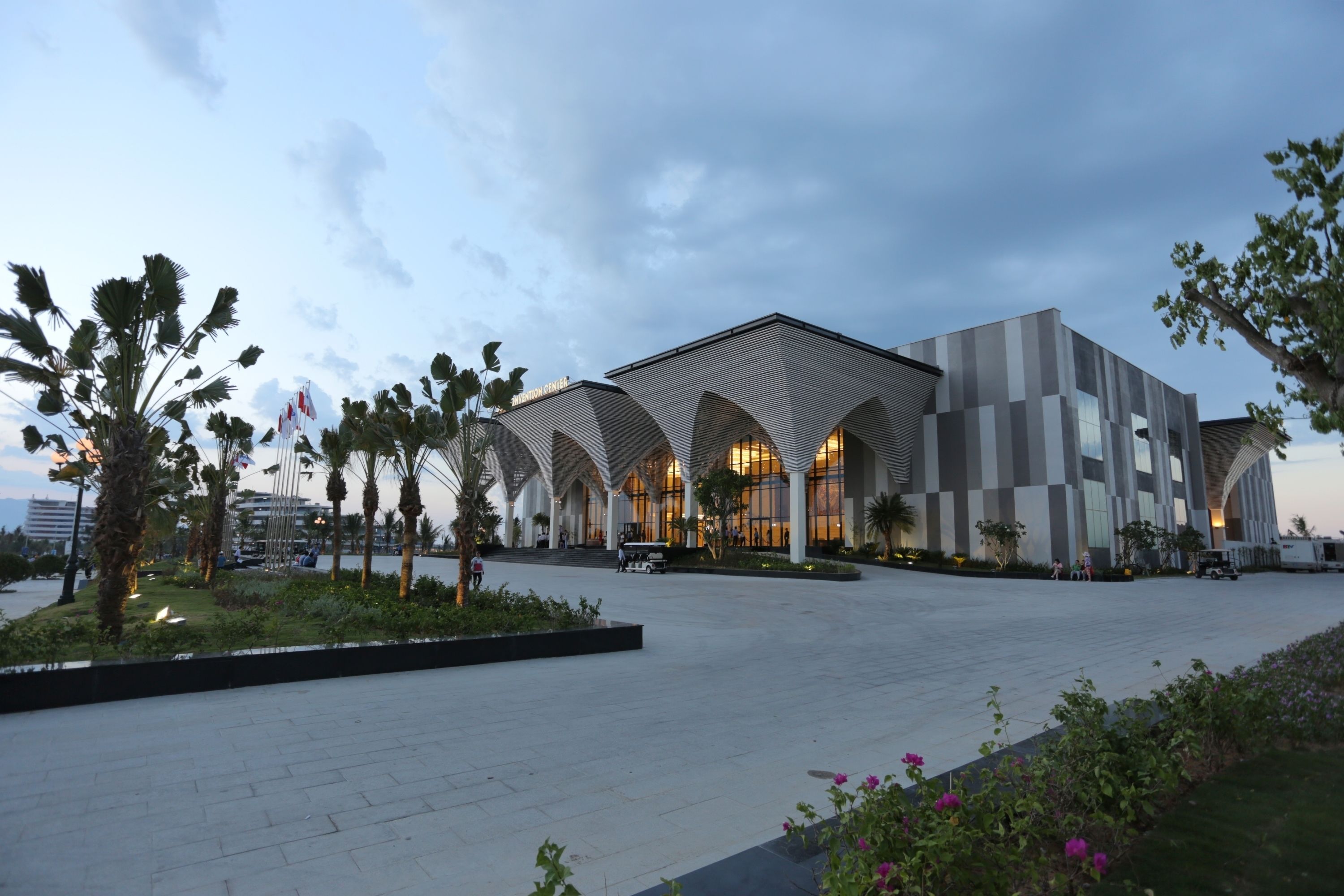 A modern building with a unique architectural design featuring arched structures and a spacious plaza.