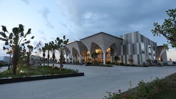 A modern building with a unique architectural design featuring arched structures and a spacious plaza.