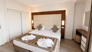 Ein Hotelzimmer mit Bett, Nachttischen, einem Kleiderschrank und einem Schreibtisch.