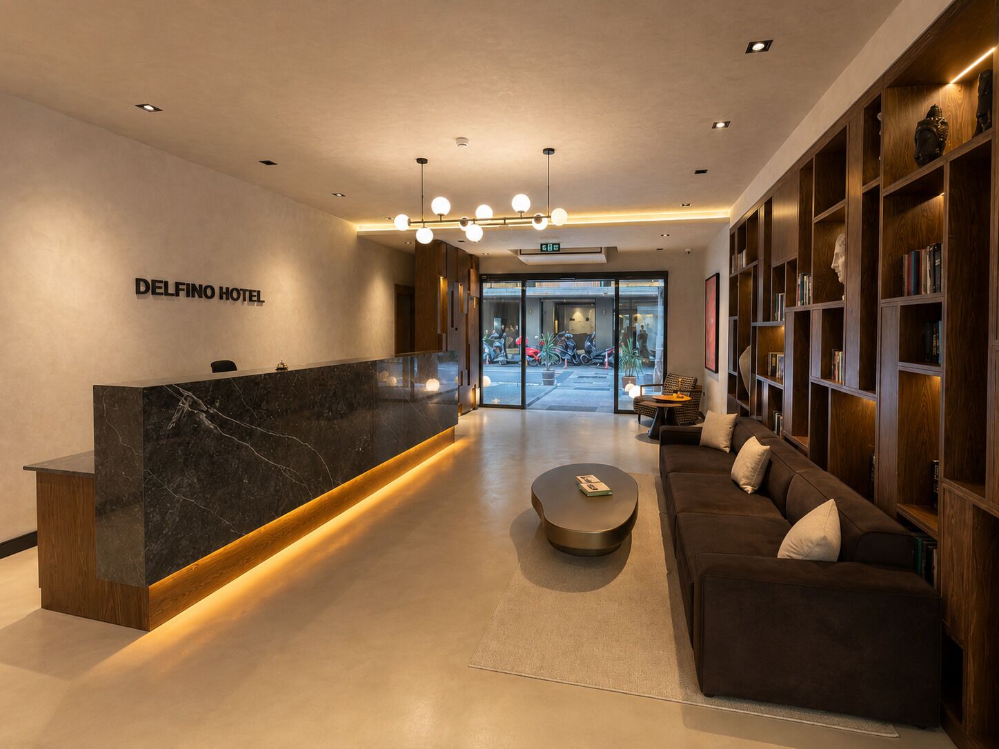A hotel reception area with a marble counter, a sofa, and a bookshelf.