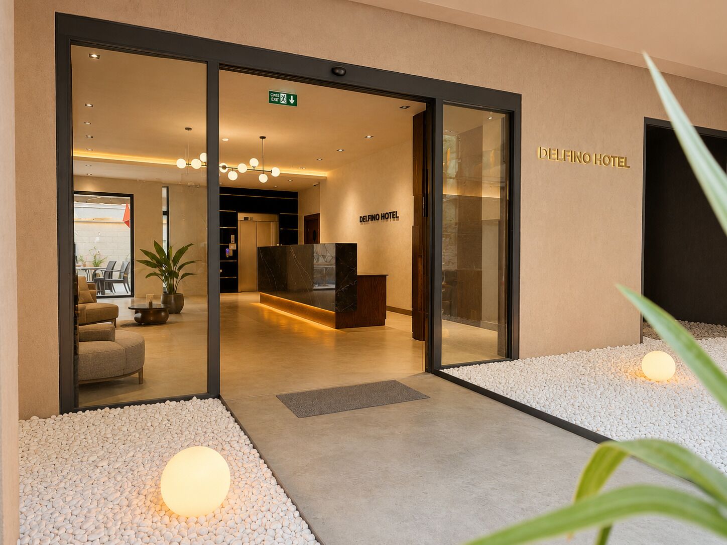 A hotel reception area with a reception desk, a seating area with sofas, and a staircase leading to the upper floors.