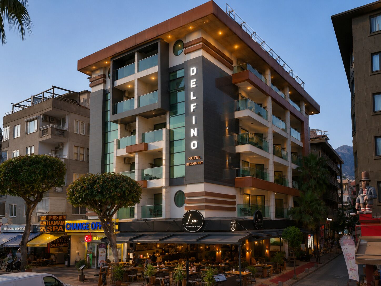 Un hotel de varios pisos con un cartel llamativo que dice 'DELFINO HOTEL RESTAURANT'.