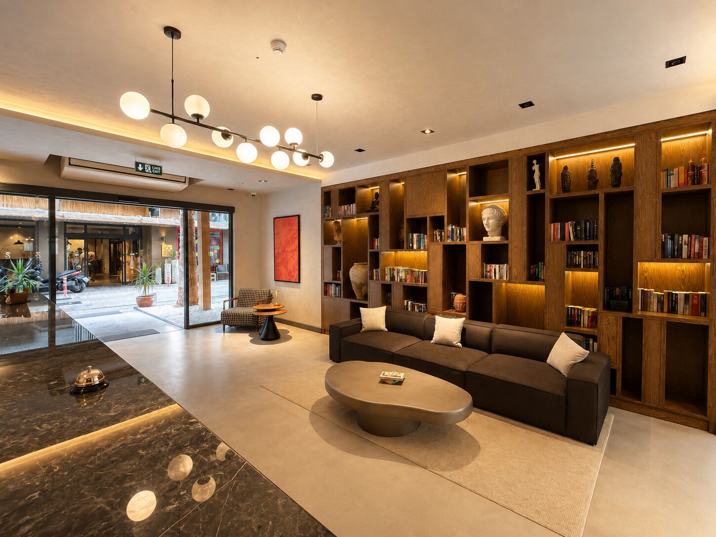 Un hall d’hôtel moderne avec un canapé, une table basse et des étagères à livres.