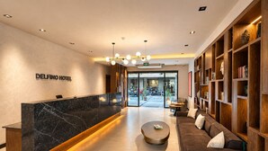 Eine Hotelhalle mit einer Rezeption, einer Couch, einem Couchtisch und einem Bücherregal.