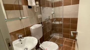 Ein modernes Badezimmer mit Toilette, Waschbecken und einer Duschkabine.