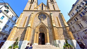 A historic church with twin towers and a large rose window. - Hotel Old Town (Sarajevo)