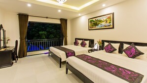 A hotel room with two beds, a nightstand, a desk, a chair, a window with curtains, a painting, and a balcony with a railing. - Hoi An Hideaway Villa (Da Nang)