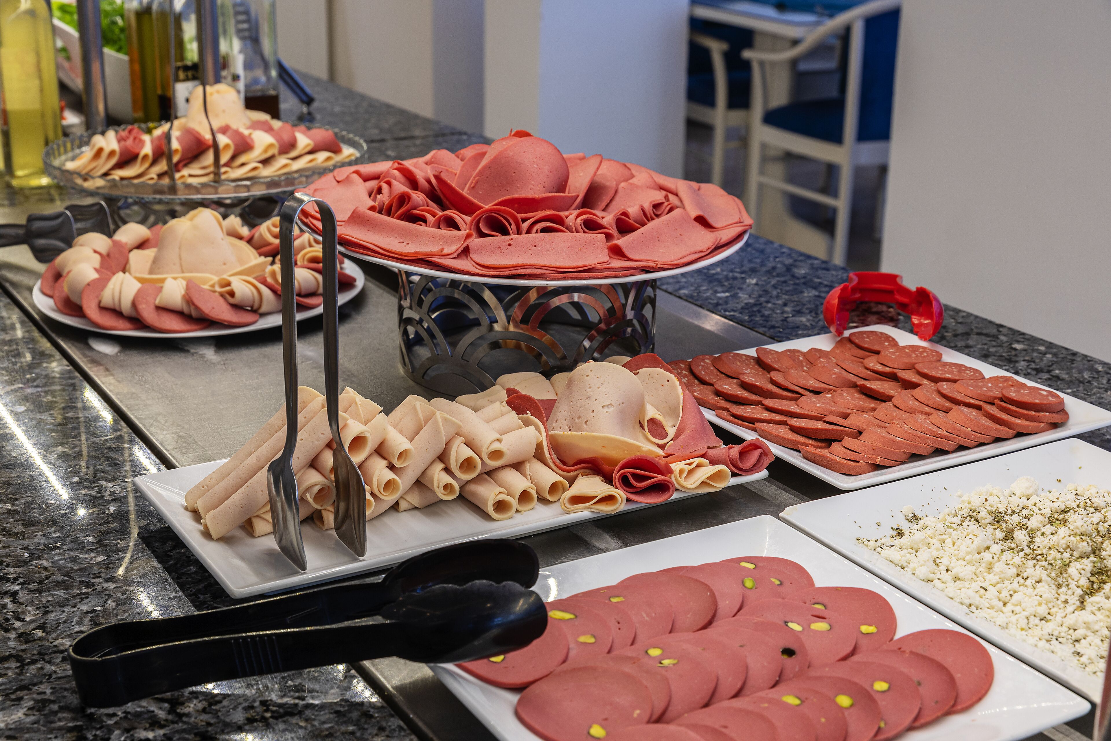 Una mesa de buffet con varios tipos de embutidos y quesos.