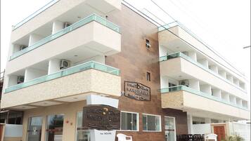 A multi-story hotel with a modern design, featuring balconies and a prominent sign for "MOLHES DA BARRA Pousada".