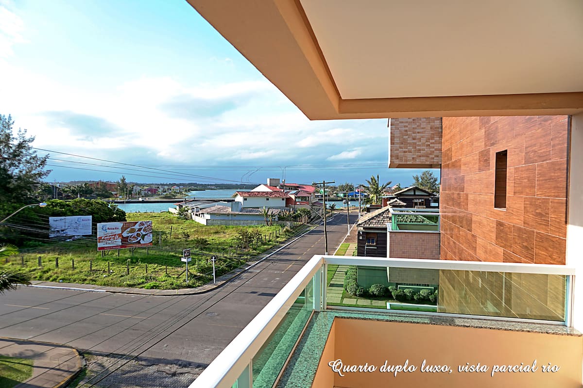 A balcony with a view of a residential area, including houses and a road.