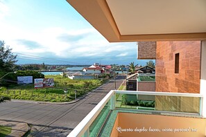 Un balcón con vista a una zona residencial, con casas y una calle.