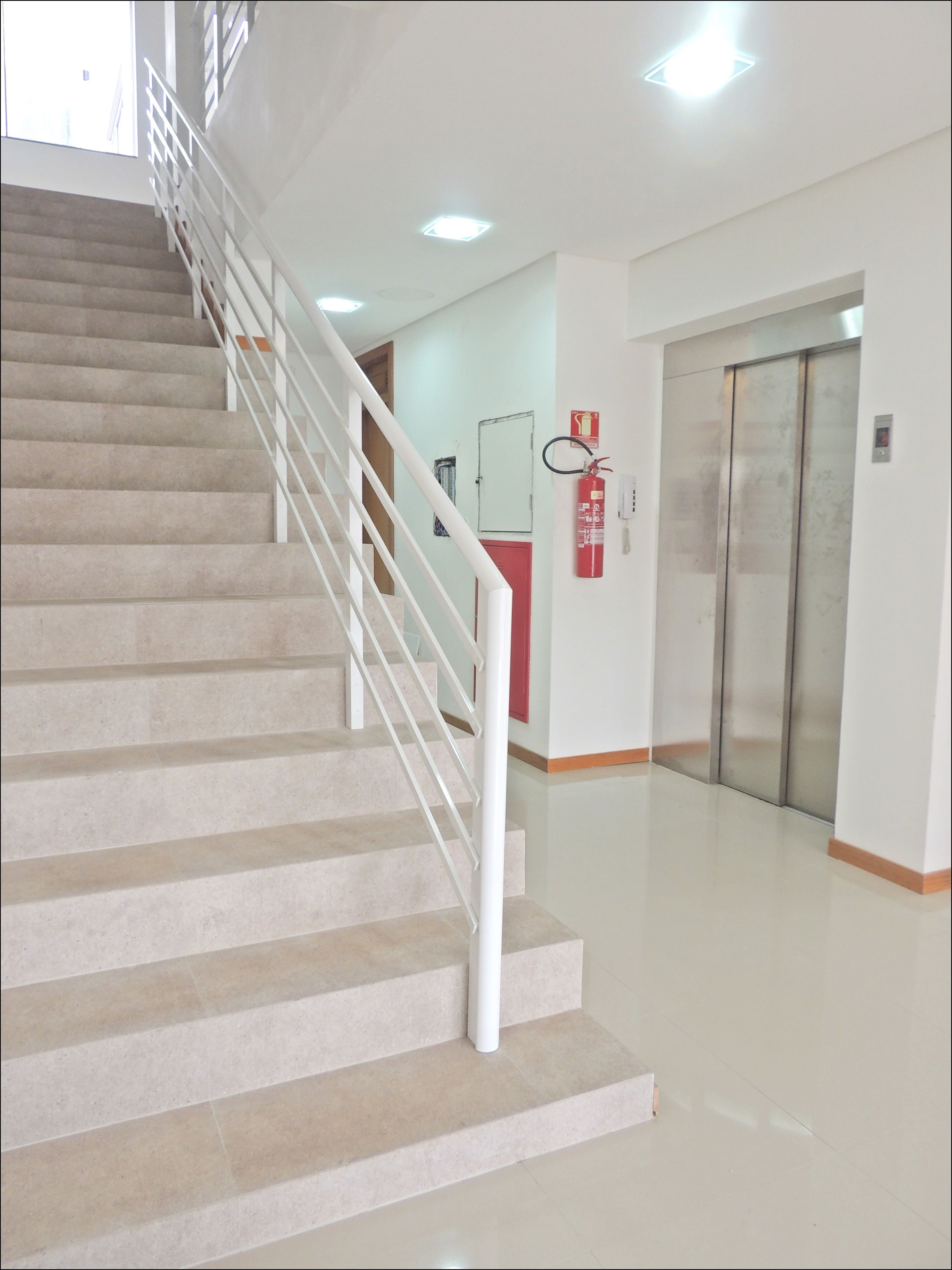 A staircase with white railings leading to a landing.