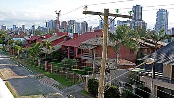 Zona residencial com mistura de edifícios tradicionais e modernos, céu claro e uma linha férrea.