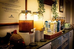 A bar area with a tap, two large jars of beverages, and a variety of drink dispensers. - Givskud Zoo - Hostel (Give)