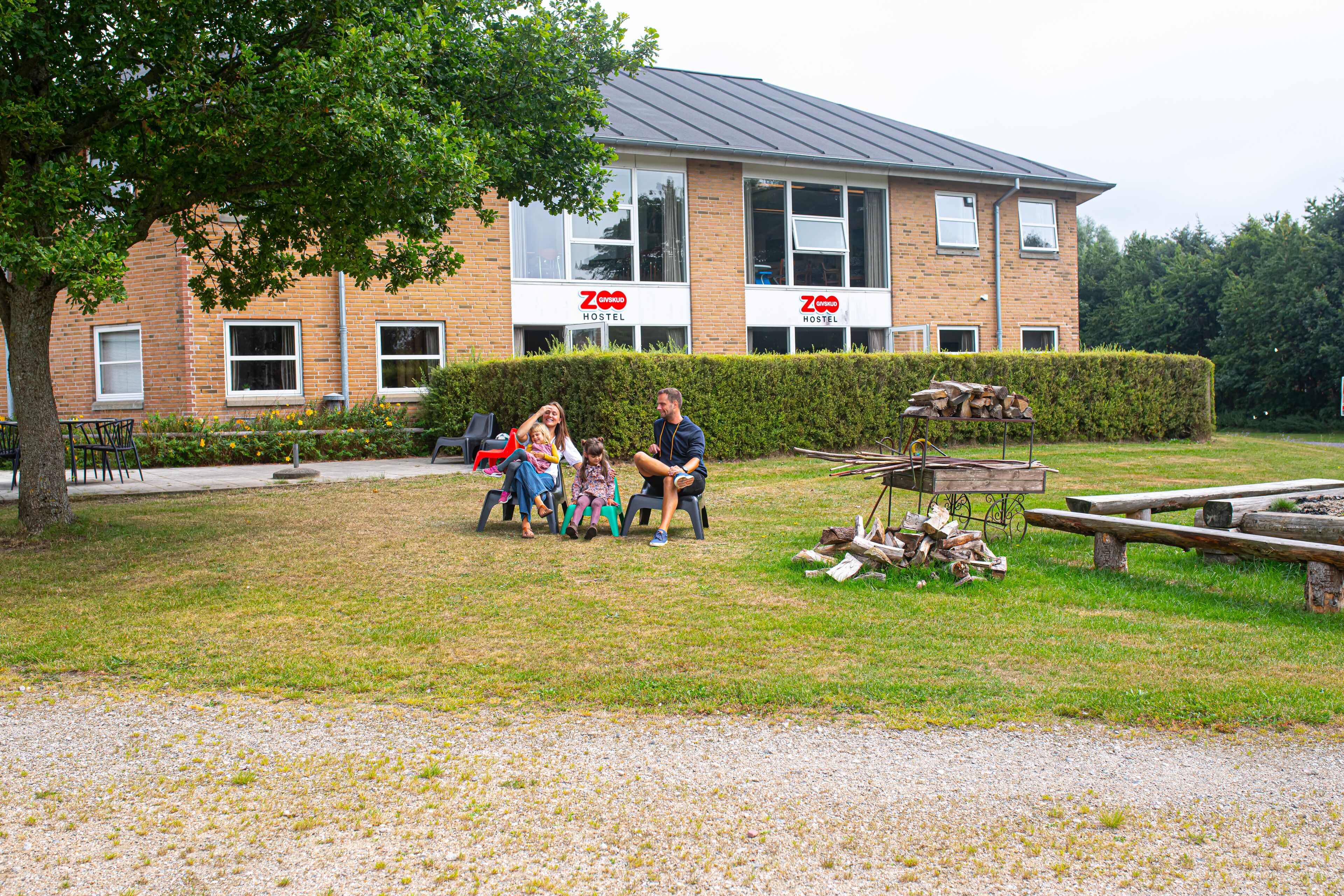 Ein Hostel mit Backsteinfassade, großen Fenstern und einem grünen Innenhof.